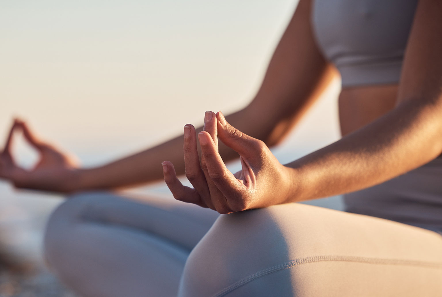 woman meditating in a lotus position with her thumb and index finger forming a circle